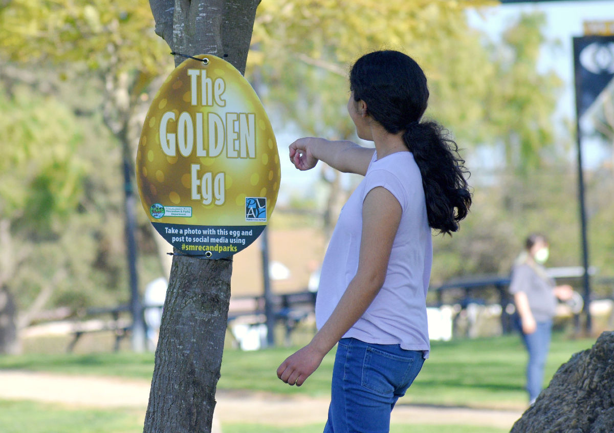 Celia Llamas points as she finds the golden egg in Preisker park Friday afternoon.